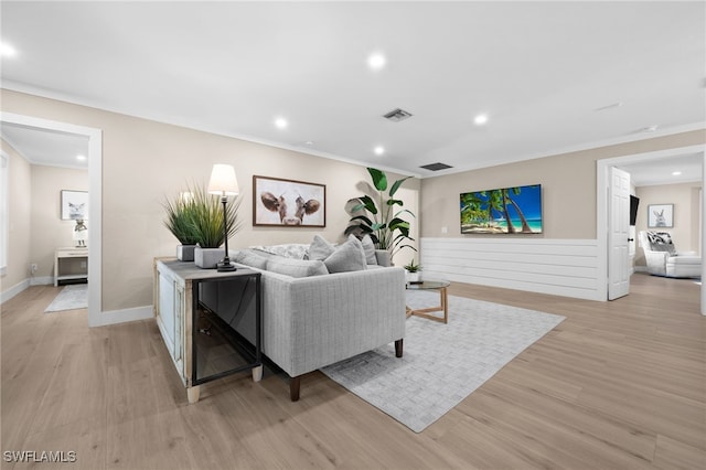 living room with light hardwood / wood-style floors and crown molding