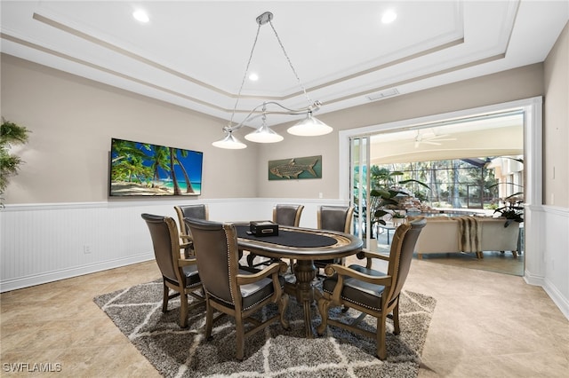 dining area with ceiling fan, a raised ceiling, and crown molding