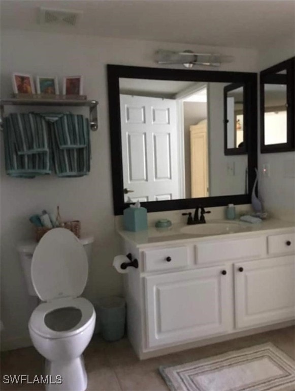 bathroom with vanity, toilet, and tile patterned floors