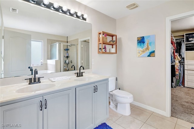 bathroom featuring vanity, toilet, tile patterned floors, and an enclosed shower