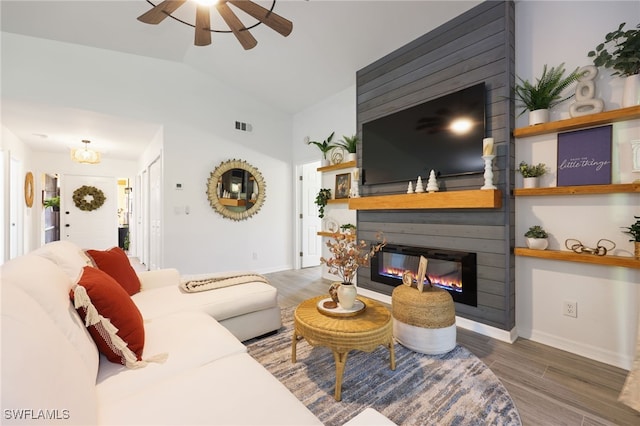 living room featuring lofted ceiling, ceiling fan, a fireplace, and dark hardwood / wood-style flooring