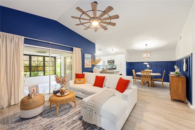 living room featuring vaulted ceiling, light wood-type flooring, and ceiling fan