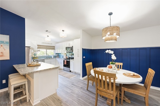 dining room featuring sink and light wood-type flooring