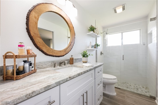 bathroom featuring vanity, hardwood / wood-style floors, toilet, and walk in shower