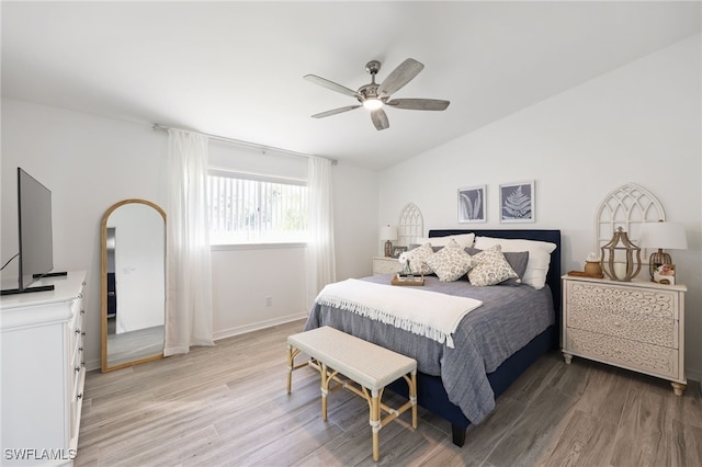 bedroom with ceiling fan, wood-type flooring, and lofted ceiling