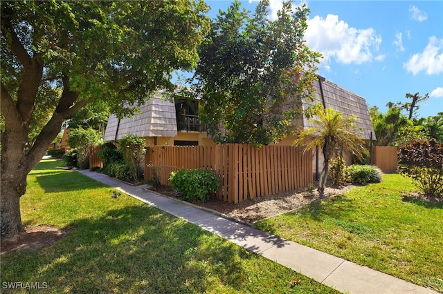 view of yard featuring a balcony and fence