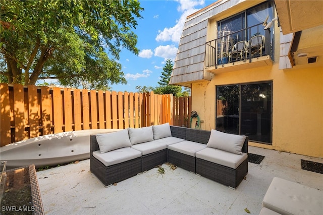 view of patio / terrace with a balcony, outdoor lounge area, and fence