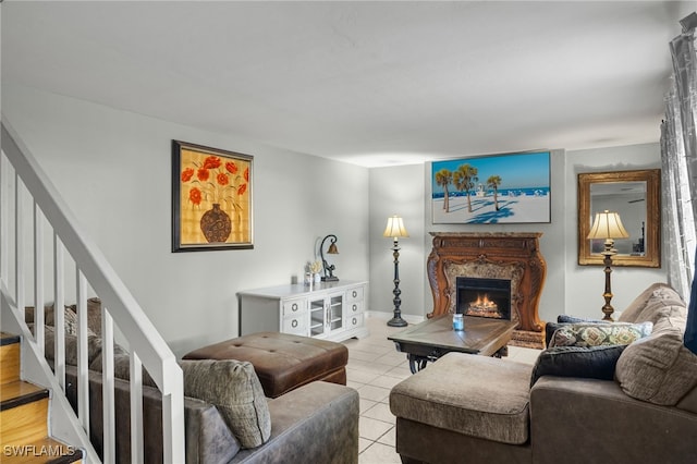 living area with stairs, light tile patterned floors, and a lit fireplace