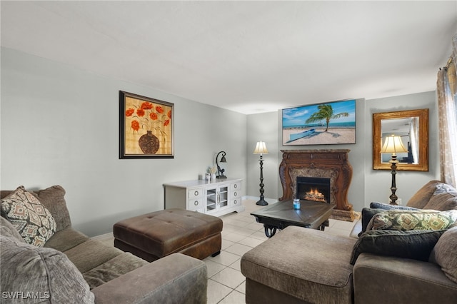 living room featuring light tile patterned floors, baseboards, and a lit fireplace