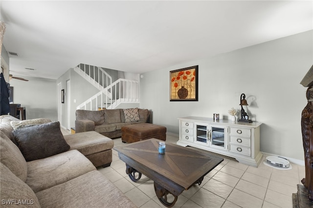 living room with light tile patterned floors, stairway, baseboards, and visible vents