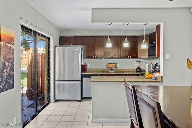 kitchen featuring dark brown cabinets, pendant lighting, light tile patterned flooring, stainless steel appliances, and a sink