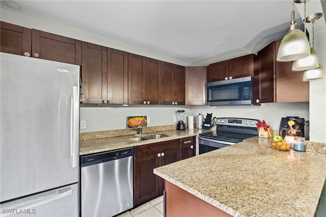 kitchen with pendant lighting, light tile patterned floors, a peninsula, stainless steel appliances, and a sink