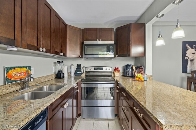 kitchen featuring pendant lighting, light stone counters, a peninsula, stainless steel appliances, and a sink