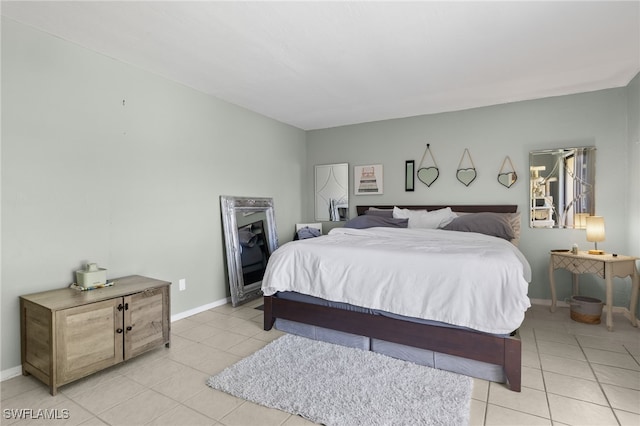 bedroom featuring light tile patterned floors and baseboards