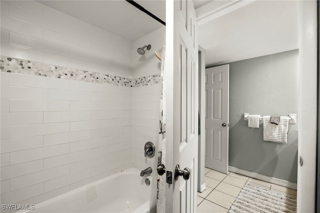 bathroom featuring baseboards, washtub / shower combination, and tile patterned flooring