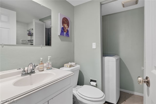 bathroom featuring tile patterned floors, toilet, vanity, and baseboards