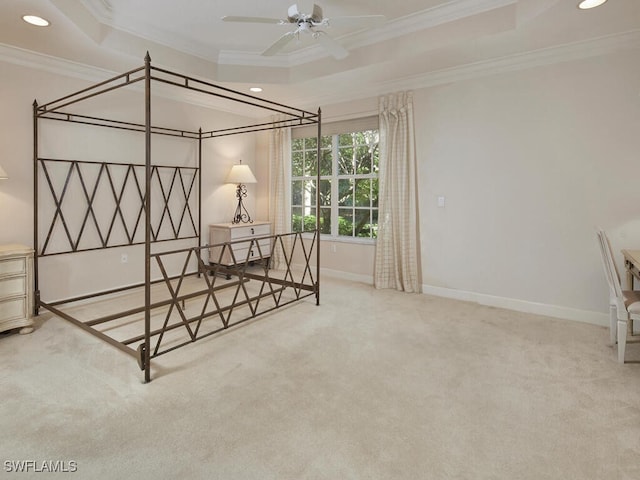 bedroom featuring crown molding, a tray ceiling, carpet, and ceiling fan