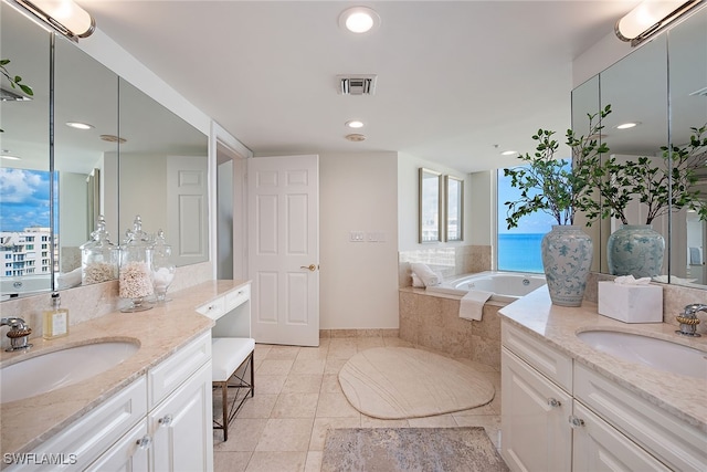 bathroom featuring vanity, tile patterned flooring, and a relaxing tiled tub