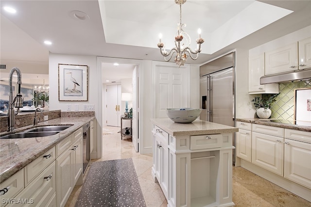 kitchen featuring a center island, light stone counters, backsplash, pendant lighting, and appliances with stainless steel finishes