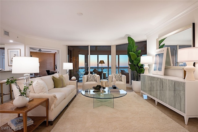 carpeted living room with a water view and ornamental molding