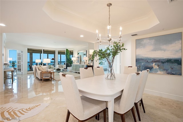 dining space featuring a raised ceiling and a chandelier