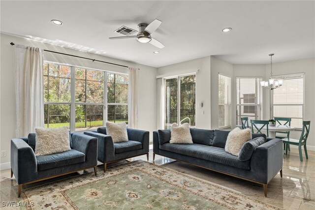 sunroom / solarium featuring ceiling fan with notable chandelier