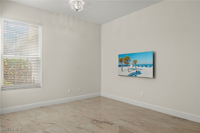 unfurnished room featuring a notable chandelier