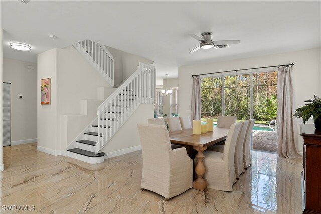 dining space featuring ceiling fan with notable chandelier