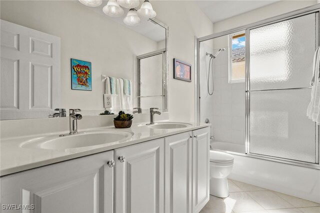 full bathroom featuring shower / bath combination with glass door, tile patterned floors, vanity, and toilet