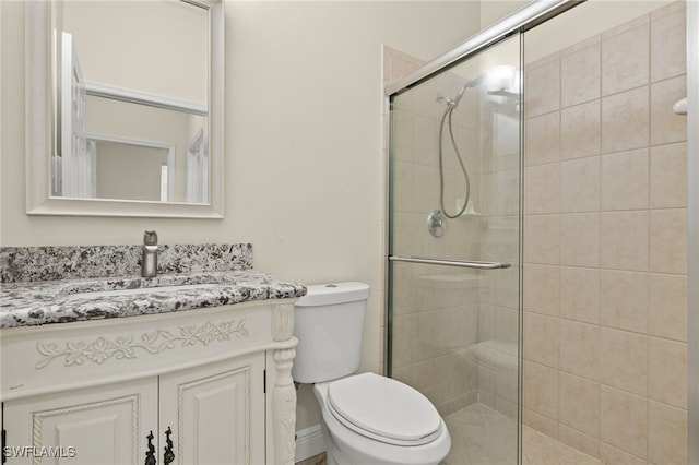 bathroom featuring vanity, an enclosed shower, and toilet