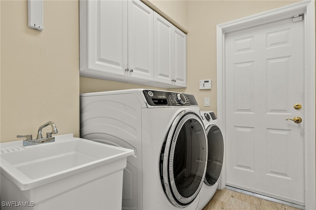 washroom featuring washer and clothes dryer, cabinets, and sink