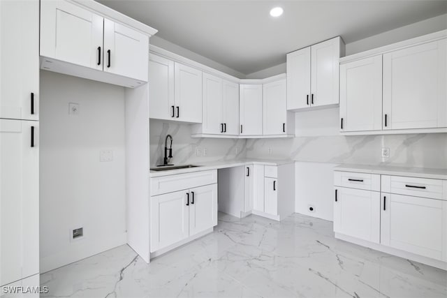 kitchen with white cabinetry, sink, and backsplash