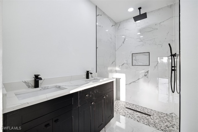 bathroom with a tile shower and vanity