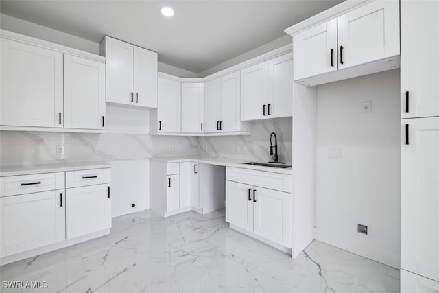 kitchen featuring sink, white cabinetry, and tasteful backsplash