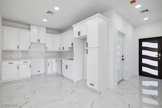 kitchen with decorative backsplash and white cabinetry