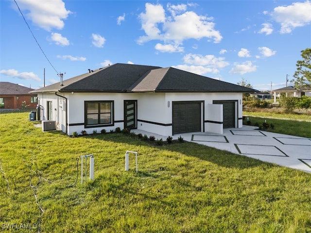 back of house with a yard, a garage, and central AC unit