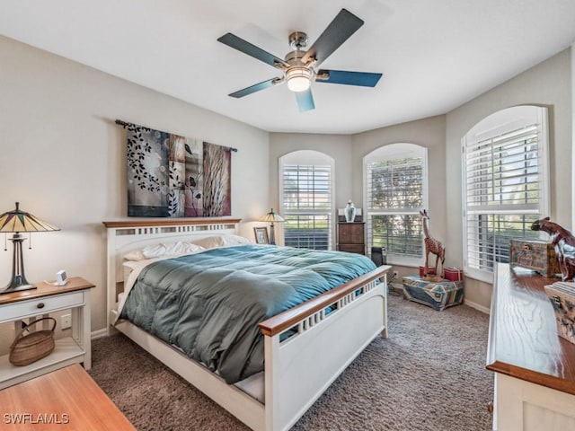 bedroom with ceiling fan and dark carpet