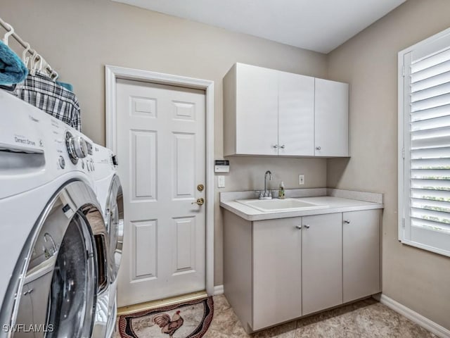 laundry area featuring sink, washing machine and dryer, and cabinets