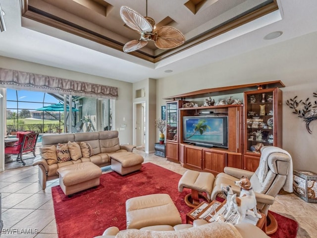 tiled living room featuring ceiling fan, crown molding, and a tray ceiling