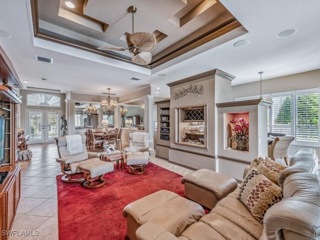 living room with light tile patterned flooring, french doors, ornamental molding, a raised ceiling, and decorative columns