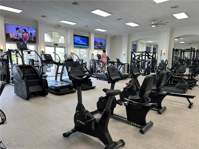 exercise room featuring ornamental molding, light colored carpet, and ceiling fan