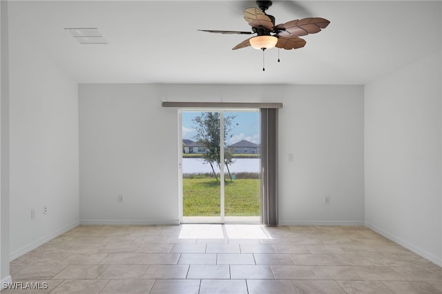 tiled spare room featuring a water view and ceiling fan