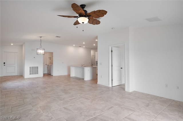 unfurnished living room with ceiling fan with notable chandelier