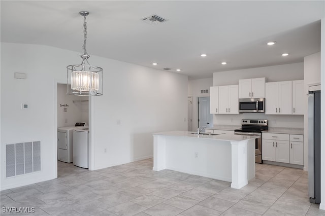 kitchen featuring white cabinets, hanging light fixtures, a center island with sink, appliances with stainless steel finishes, and washer and clothes dryer