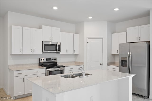 kitchen with stainless steel appliances, sink, a center island with sink, and white cabinets