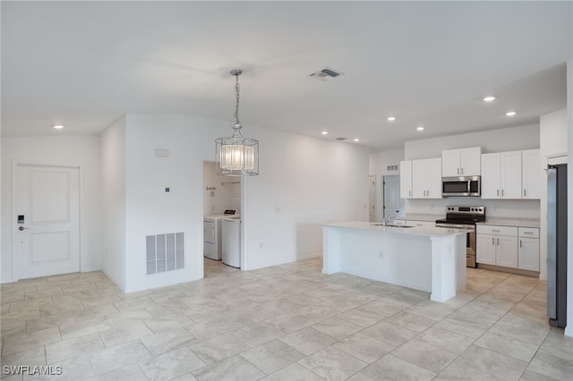 kitchen featuring hanging light fixtures, a center island with sink, separate washer and dryer, white cabinetry, and appliances with stainless steel finishes