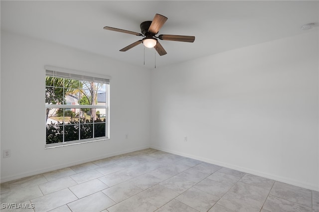 tiled spare room featuring ceiling fan