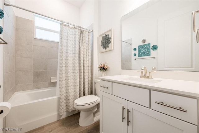 bathroom with toilet, wood finished floors, vanity, and shower / tub combo with curtain