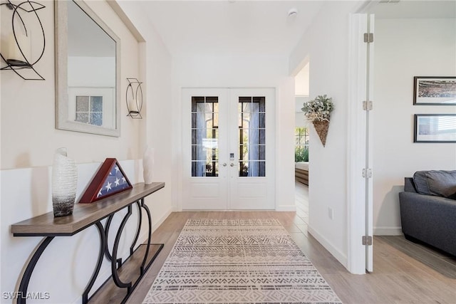 foyer entrance featuring french doors and light hardwood / wood-style floors