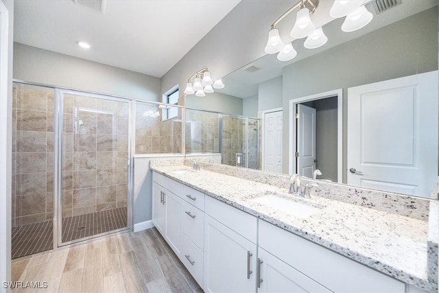 bathroom featuring vanity, a shower with shower door, and wood-type flooring